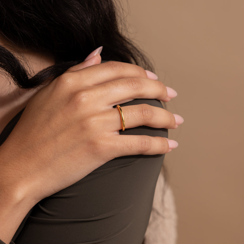 A hand with pale pink manicured nails wears the Minimal Stacking Ring on the ring finger.