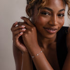 Woman wearing a silver floral diamond bracelet with a neutral background