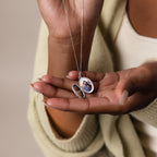 A person holds an open Floral Handwriting Locket Necklace, revealing a small photo tucked inside.