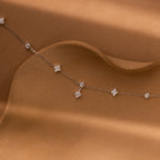 The Ivy Diamond Station Necklace in Silver features small diamond clusters with floral-inspired accents on a wavy, textured design.