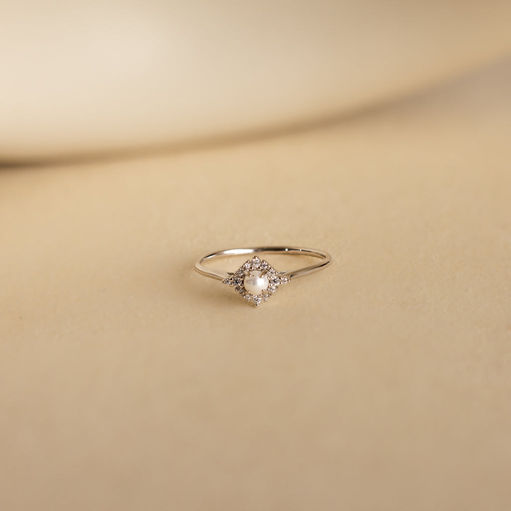 The Vintage Pave Pearl Ring in Sterling Silver showcases a central pearl with pavé diamonds in a square setting on a reflective gold band—an elegant and exquisite Christmas gift choice.