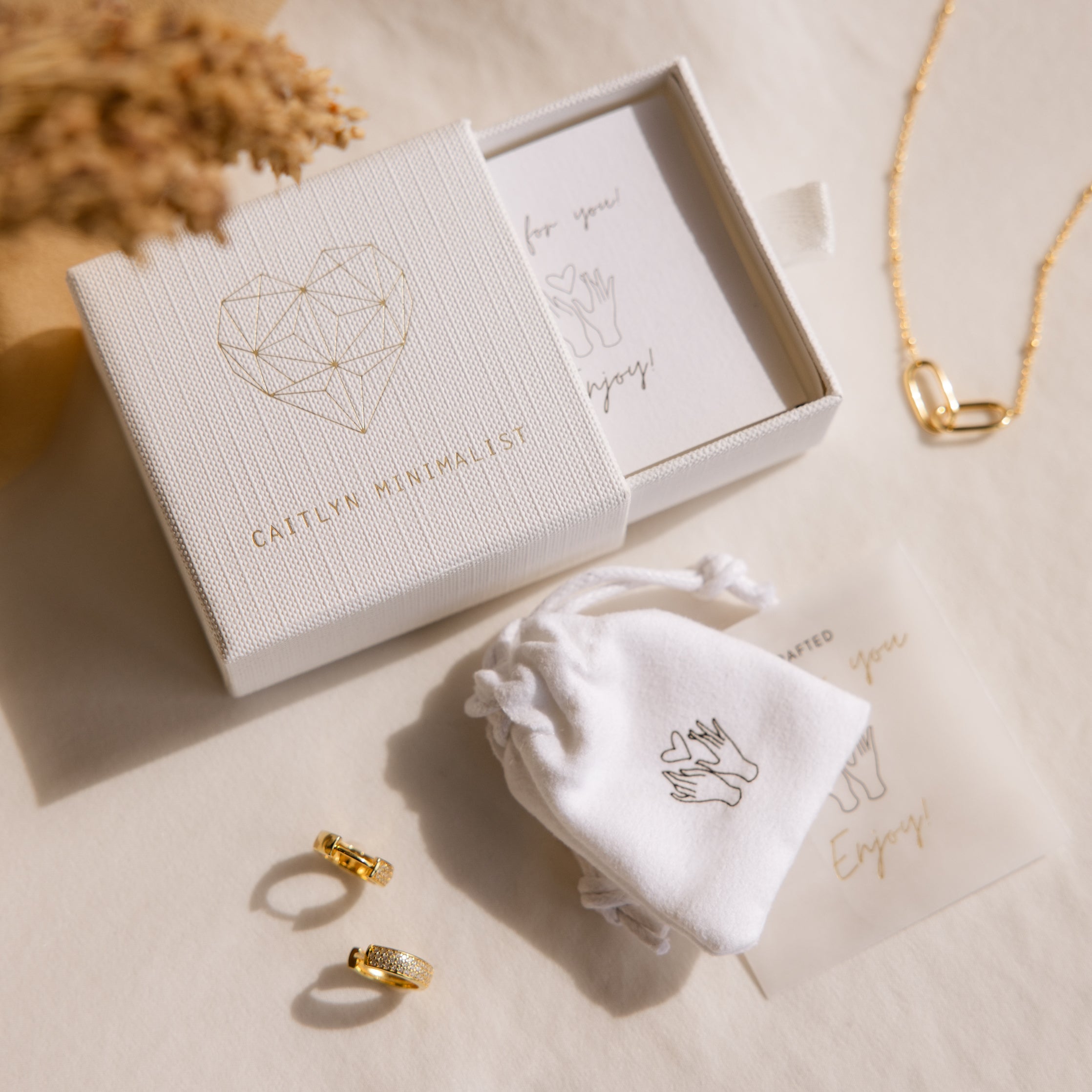 Jady Wire Diamond Hoops in 18K gold with pave diamond detailing, shown with branded white jewelry box and soft pouch on.
