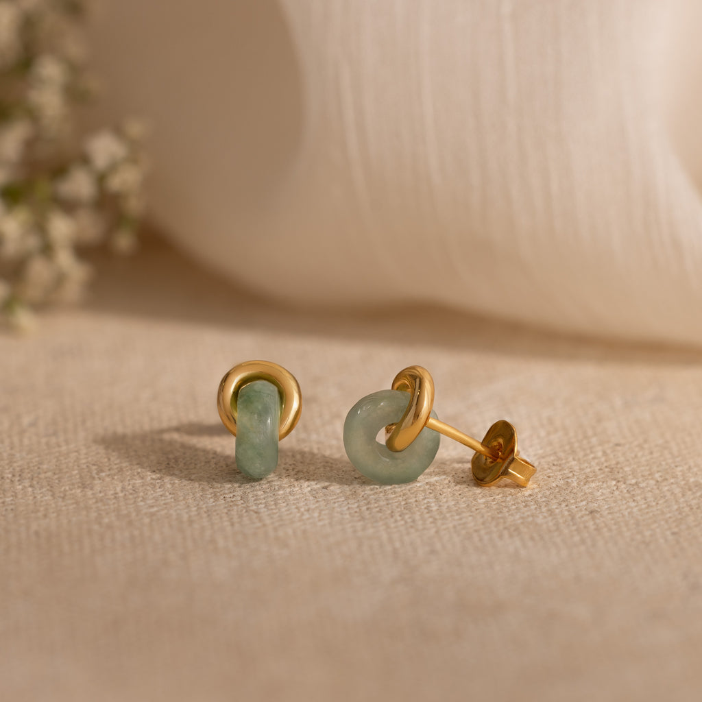 Gold stud earrings with smooth, light green jade halo drops.