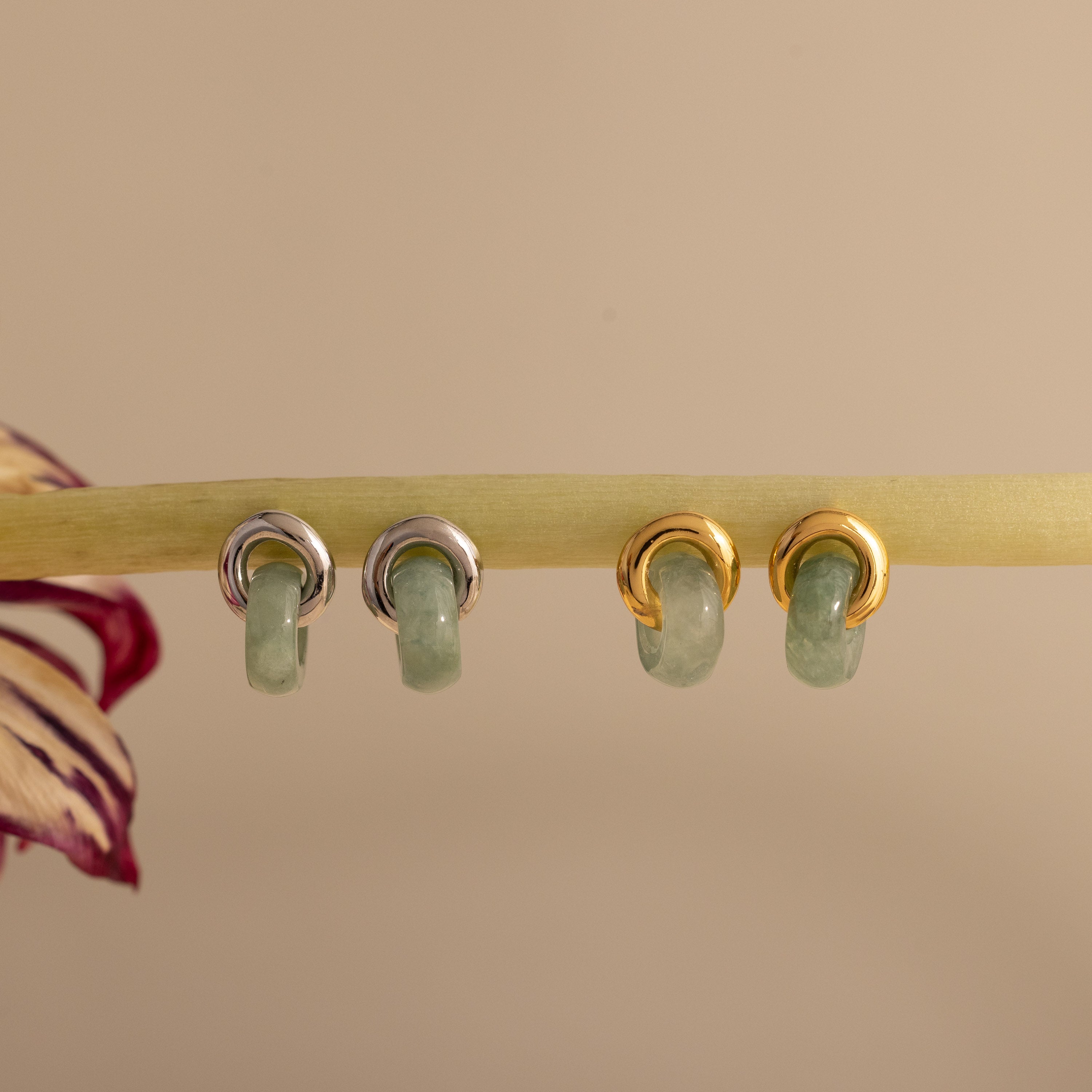 Two pairs of Jade Halo Drop Studs, one silver and one gold, featuring smooth green jade.