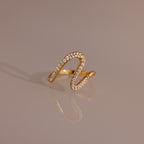 Pave Wave Ring featuring a wavy, abstract gold design encrusted with small diamonds, ideal for stacking and beautifully set against a neutral background.