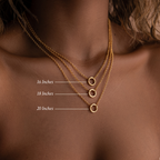 Three Rolo Circle Charm Necklaces in 18K gold, layered at 16", 18", and 20" lengths on a woman's neck, create a chic minimalist look with classic rolo link chains for effortless elegance.