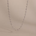 Silver mariner chain necklace with polished oval links, displayed against a neutral beige background.