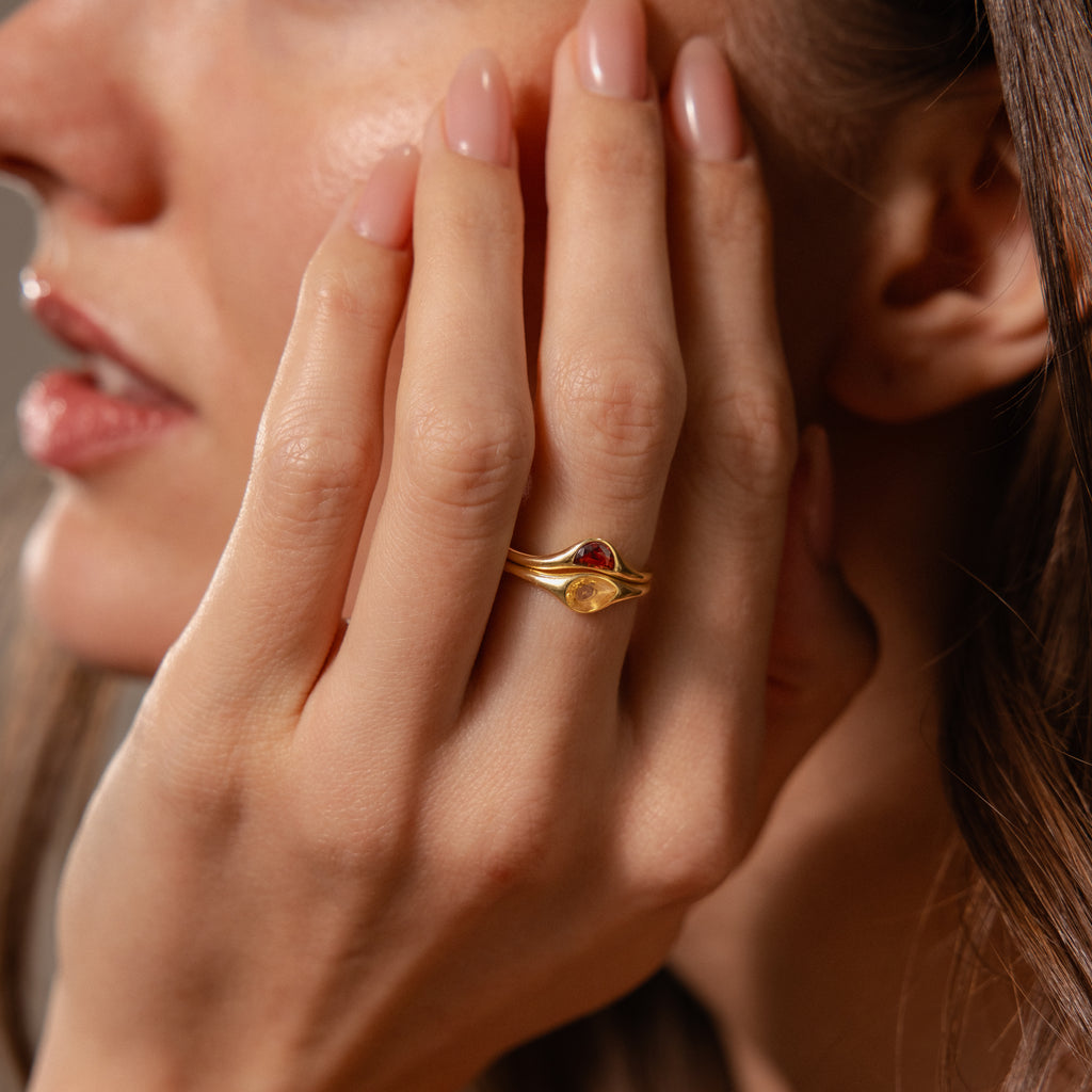 A woman with manicured nails showcases the Sculpted Toi et Moi Ring Set in Silver, holding her hand to her face.
