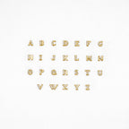 Pave Initial Studs: Gold alphabet letters with rhinestones, arranged in three rows on a white background—ideal as custom initial stud earrings or a unique personalized gift.