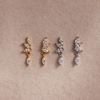 Two pairs of CZ diamond drop earrings in gold and silver, each with four marquise-cut stones.