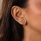 Close-up of a womans ear wearing Mini Diamond Beaded Huggies—modern huggie earrings featuring gemstone beads in unique shapes and sizes.