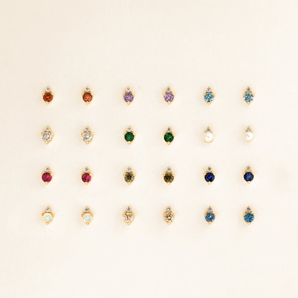 Twenty Raindrop Peridot Studs are arranged in five neat rows on a light background, each earring adding a vibrant touch to the elegant display.