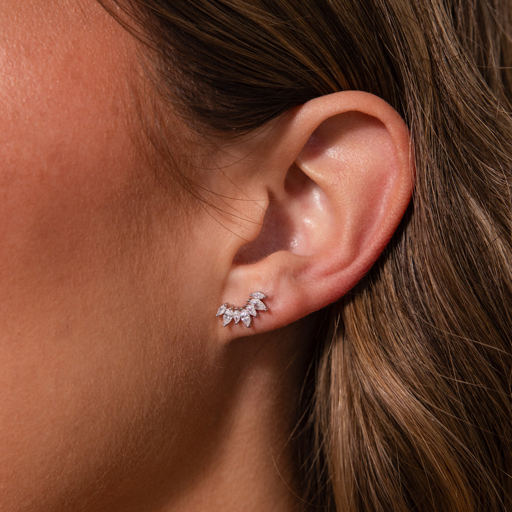 Close-up of a womans ear adorned with Marquise Diamond Arc Climbers in Silver, featuring elegant leaf-shaped marquise stones that accentuate her look.