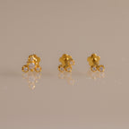 Close up of three gold crystal cluster flat back stud earrings featuring graduated two, three, and four stone designs.