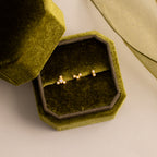 Three dainty crystal cluster flat back stud earrings in gold displayed inside an olive green velvet jewelry box.