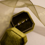 Three dainty crystal cluster flat back stud earrings in silver displayed inside an olive green velvet jewelry box.