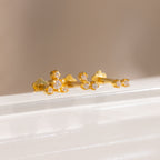 Three gold crystal cluster flat back stud earrings displayed on a white surface, featuring delicate two, three, and four stone designs.