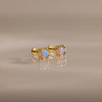 Blue Opal Prism Studs in 18K Gold featuring square blue opals, showcased on a smooth, reflective surface.