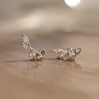 The Diamond Starfall Climbers in Silver are delicate earrings featuring a marquise cut and round clear stones in a floral design.