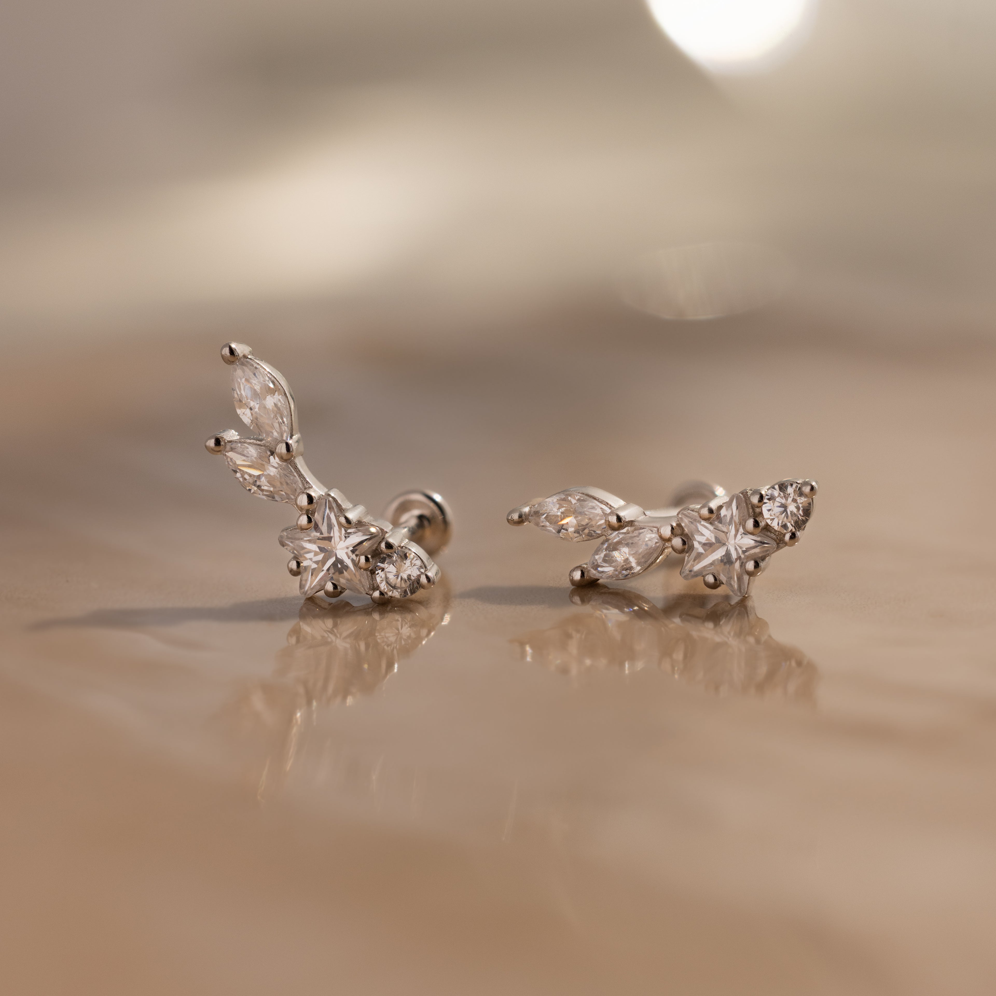 The Diamond Starfall Climbers in Silver are delicate earrings featuring a marquise cut and round clear stones in a floral design.