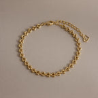 Tiny Link Heart Bracelet in gold featuring interlocking polished heart links on a neutral background.