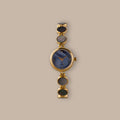 Gold-tone watch with blue mother of pearl dial and iridescent abalone links.