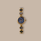 Gold-tone watch with blue mother of pearl dial and iridescent abalone links.