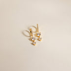 Caroline Pave Drop Huggies gold earrings with sparkling stones displayed on a neutral, light background.