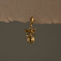 Pave Bow Ornament Charm featuring a bow and round charm with delicate details, displayed on a neutral background.