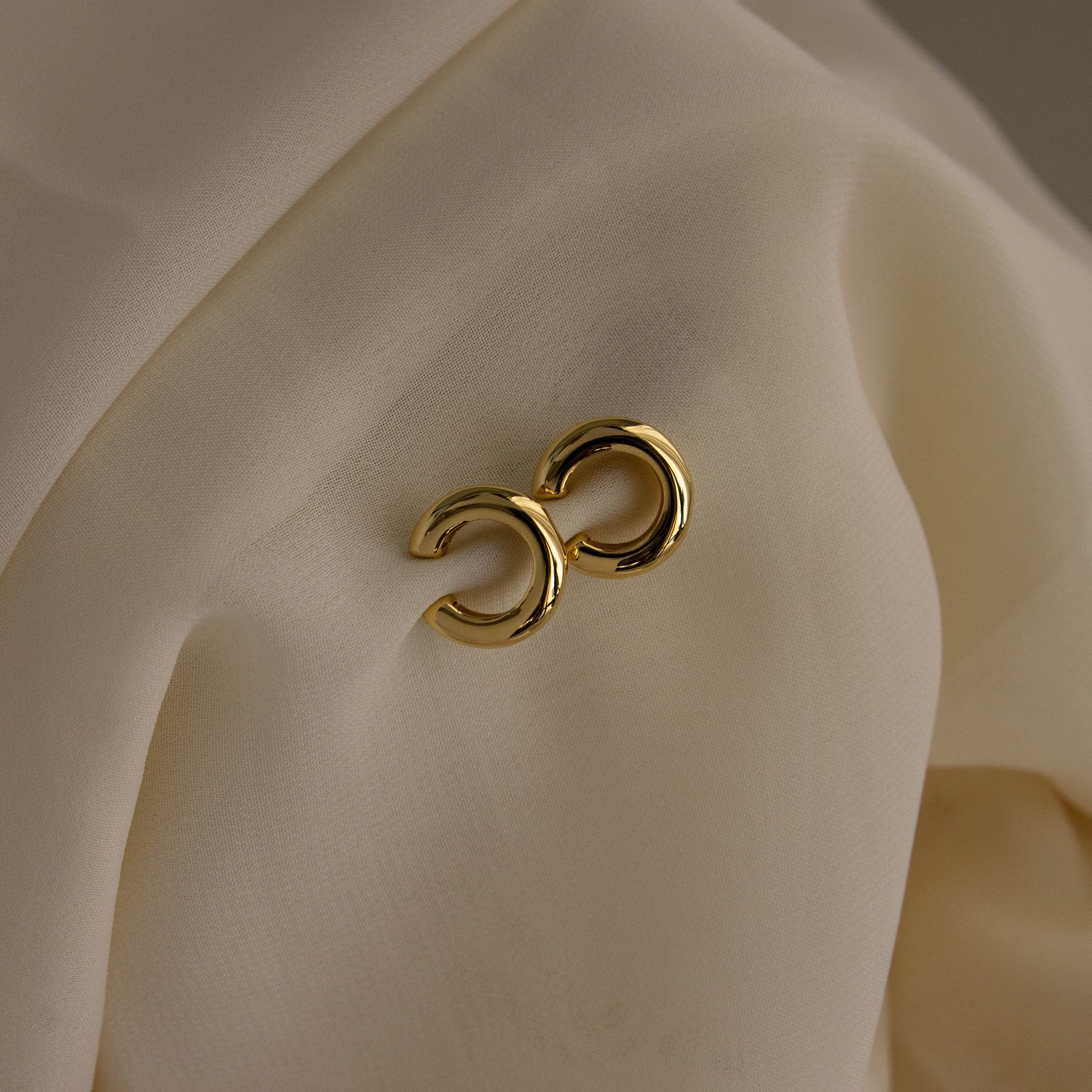 Chunky Ear Cuffs displayed on draped, cream-colored fabric.