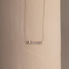 Dainty silver Brooke bubble name plate necklace displayed against a neutral surface.
