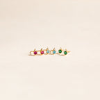 A gold ring with five colorful gemstones—pink, blue, and green—in a row on a light background, perfect for pairing with Raindrop Birthstone Studs or dainty earrings.