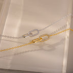 The Pave Linked Pendant Bracelet features interlocking links adorned with sparkling stones, showcasing its gem-encrusted elegance on a beige surface.