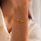 Model wearing the Rope Knot Chain Bracelet in gold with a center knot detail and duo chain design.