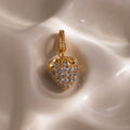 Aquamarine Blue Raspberry Charm with pavé stones and small clear gemstones on a smooth, cream-colored surface—a strikingly elegant piece to enhance any jewelry collection.