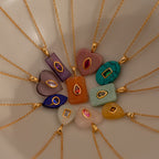 Twelve Emerald Crystal Necklaces on gold chains are arranged in a circle on a neutral background, creating a stunning jewelry display.