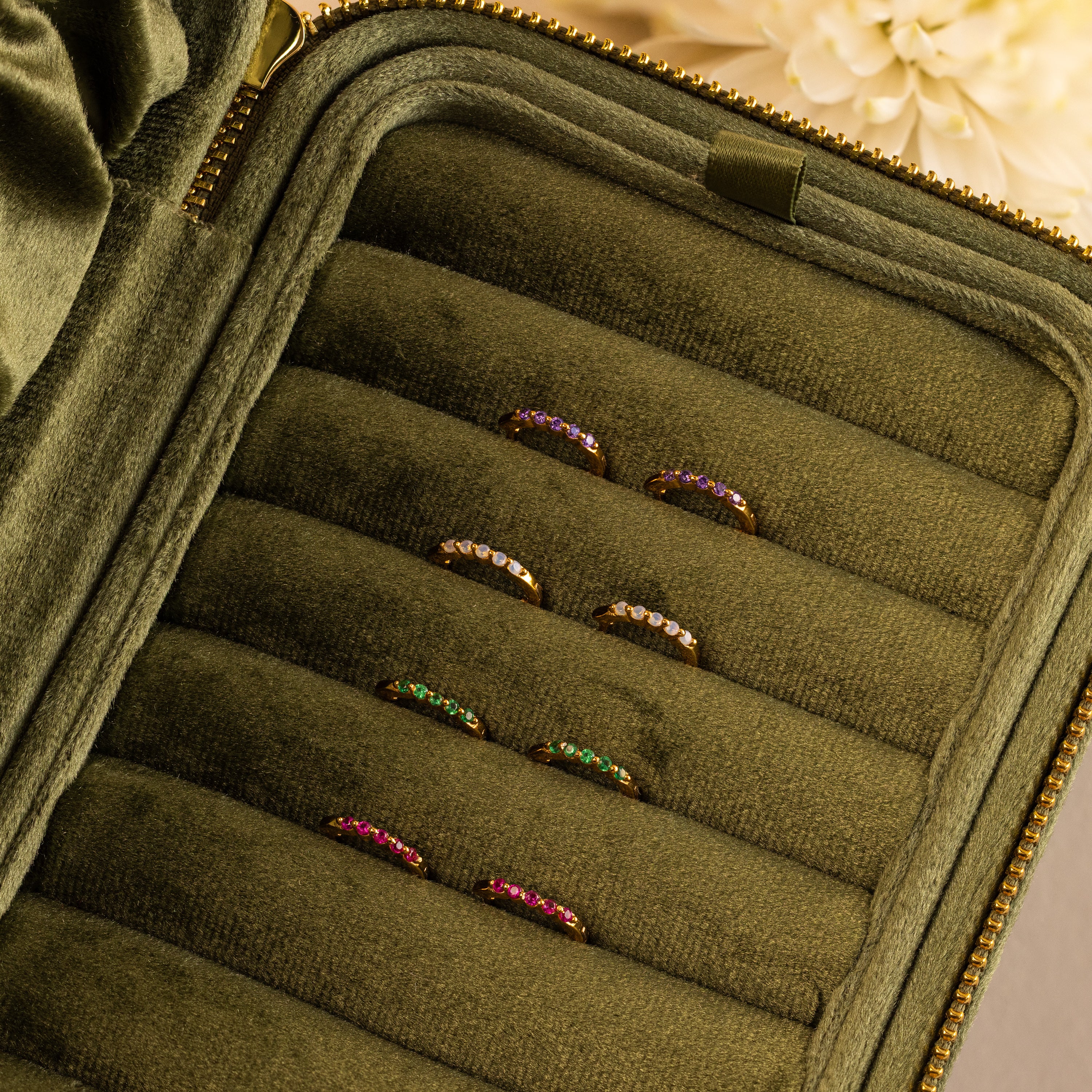 Inside Out Peridot Huggies are displayed in an olive green velvet jewelry case, perfect for pairing with gemstone earrings or stacking for a vibrant, personalized look.