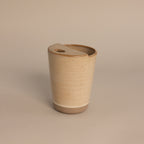The Everyday Ceramic Mug comes with a matching lid and features a subtle speckled beige glaze, shown against a light neutral background.