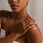 A woman rests her hand on her shoulder, showcasing the Skinny Agate Ring—an ideal pick for gemstone lovers enchanted by its elegant green marbling.