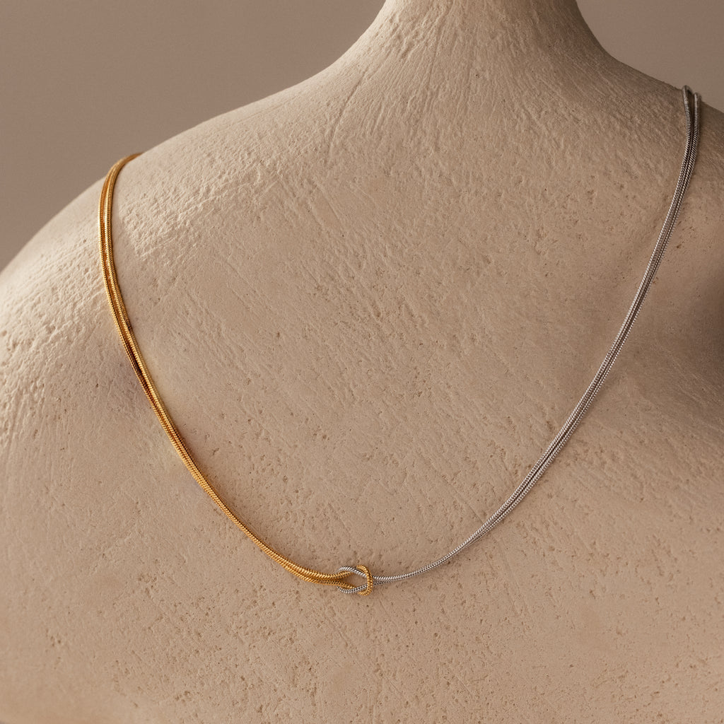 Love Knot Chain Necklace in Mixed Metal displayed on a neutral textured mannequin bust.