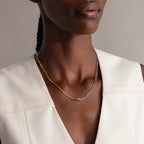 A woman wears the Love Knot Chain Necklace in Mixed Metal, featuring silver and gold tones, paired with an off-white sleeveless top.