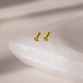Geometric Pink Tourmaline Flat Back Studs—gold square earrings with clear stones inspired by geometric designs, shown on a white textured jewelry tray.