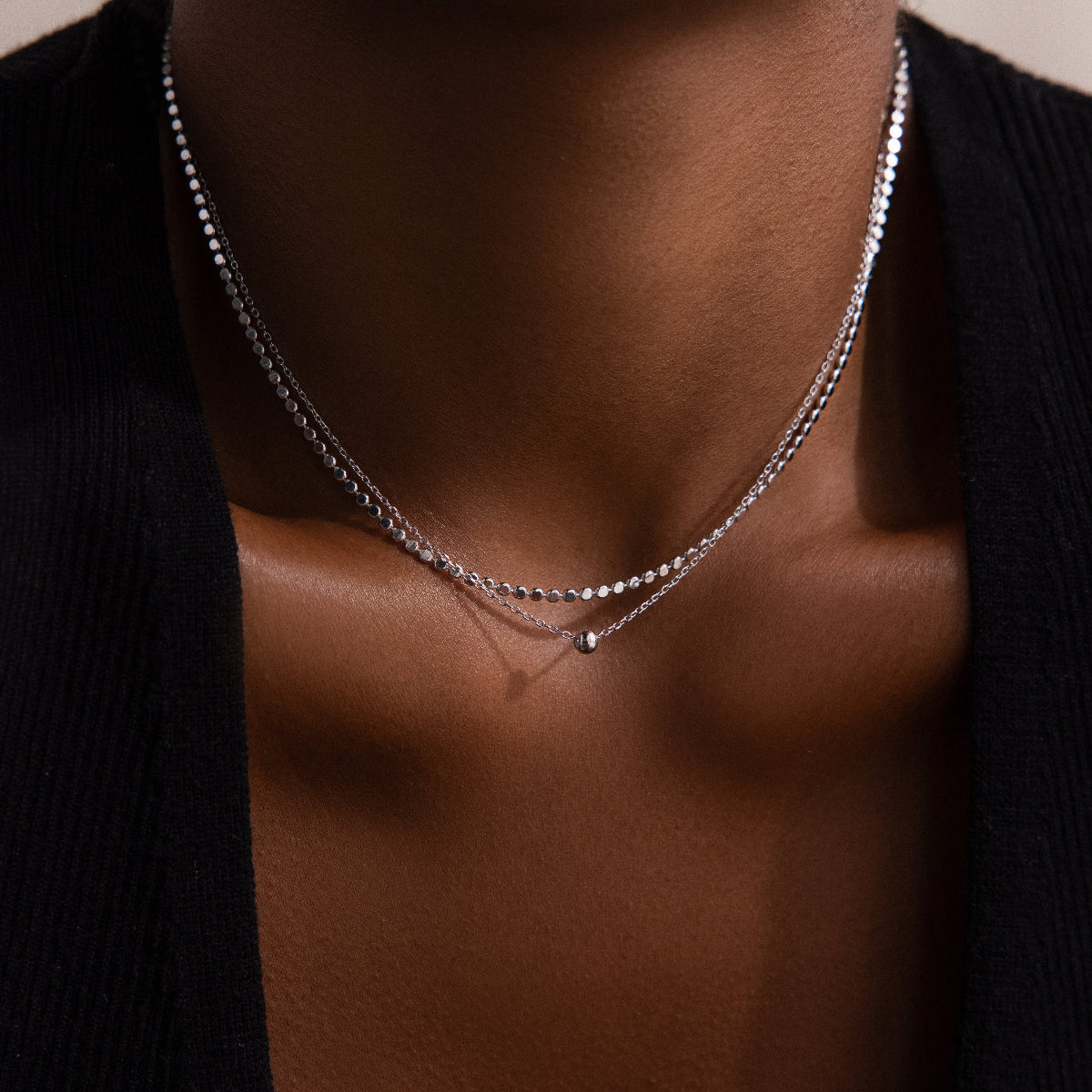 Silver beaded necklace on a woman  wearing a black garment