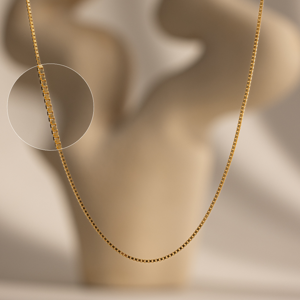 Gold box chain on a neutral background