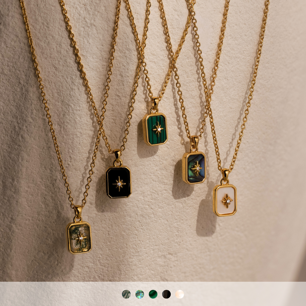 Five North Star Gemstone Necklaces in 18K Gold, each featuring a rectangular crystal pendant, are displayed against a soft beige background.