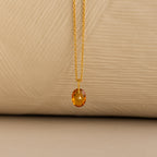 Close up of a Gold North Star Birthstone Necklace with a Yellow Topaz Gemstone.