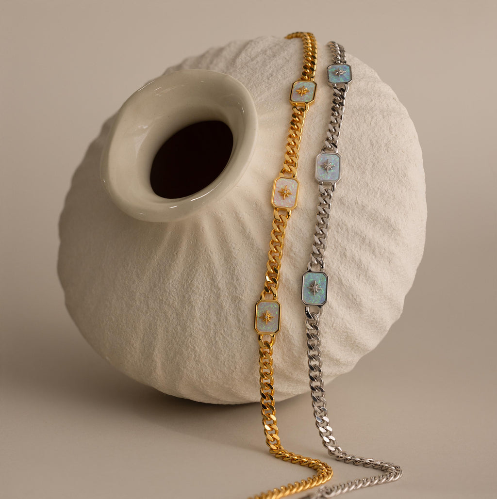 Gold & Silver North Star Opal Trio Curb Chain Necklaces draped over a cream vase.