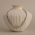 Silver North Star Trio Opal Curb Chain Necklace displayed on a textured cream vase.