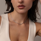 Woman wearing a cream sleeveless top and the Love Knot Chain Necklace in White Gold, shown from shoulders to chin.