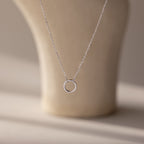 The Large Rolo Clasp Necklace in Sterling Silver features a simple circular pendant and a bold rolo clasp, making it a versatile accessory. Displayed on a neutral background, this delicate piece is perfect for everyday wear.